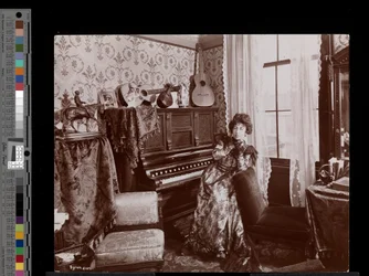 Anita Chartres seduta a un pianoforte automatico, c.1898